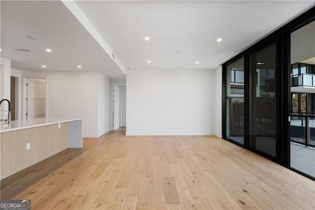 unfurnished living room featuring light hardwood / wood-style floors and floor to ceiling windows