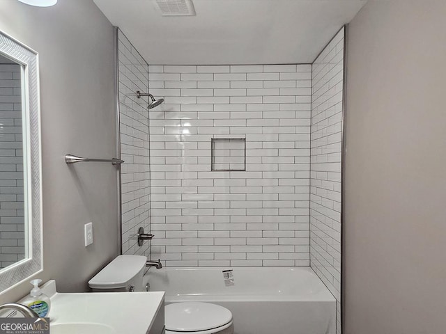 full bathroom with tiled shower / bath combo, vanity, and toilet