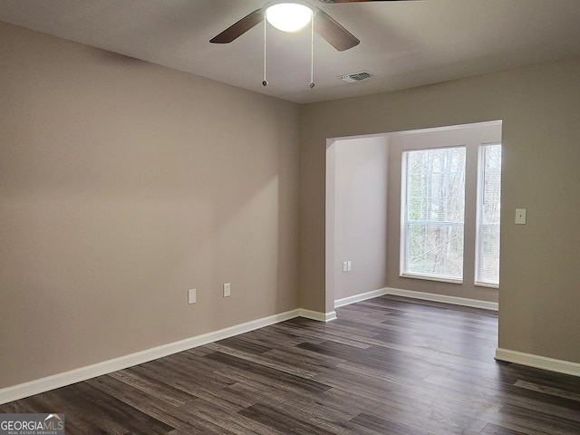 empty room with ceiling fan and dark wood-type flooring