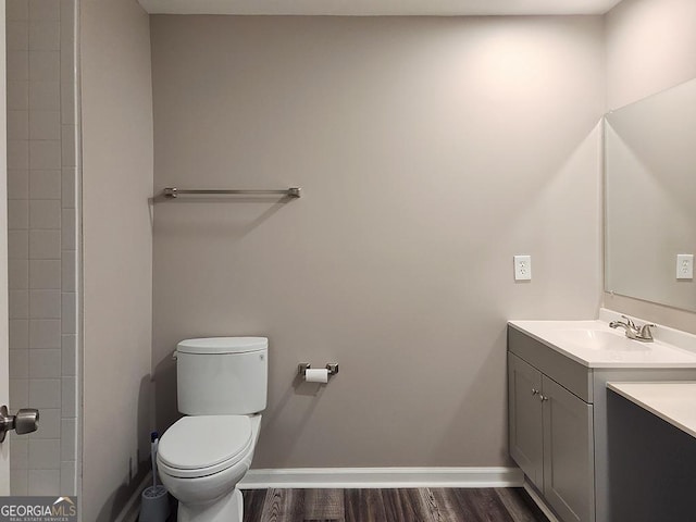 bathroom featuring wood-type flooring, toilet, and vanity