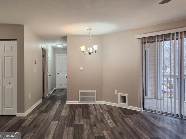 unfurnished dining area featuring dark wood-type flooring and a chandelier