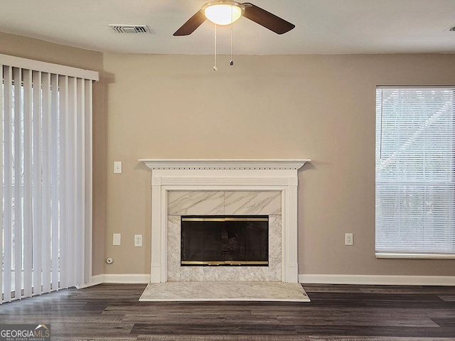 room details featuring ceiling fan, wood-type flooring, and a premium fireplace