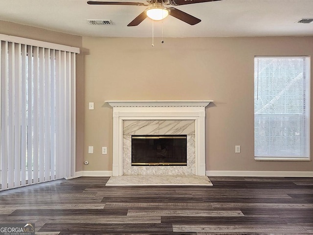 unfurnished living room featuring ceiling fan, dark hardwood / wood-style flooring, and a fireplace