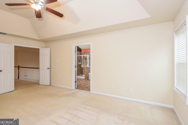 unfurnished bedroom with ceiling fan, light colored carpet, and vaulted ceiling