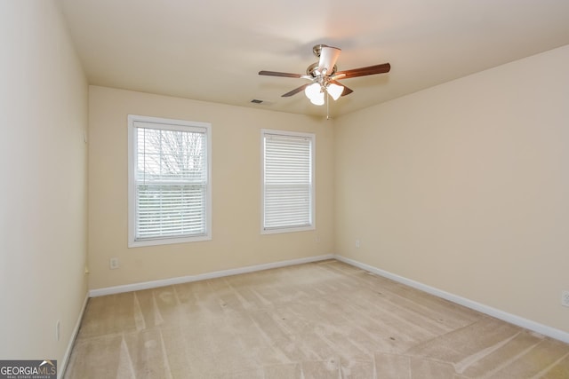 spare room with ceiling fan and light colored carpet