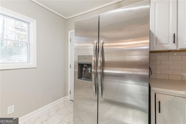 kitchen featuring white cabinets, tasteful backsplash, and stainless steel fridge