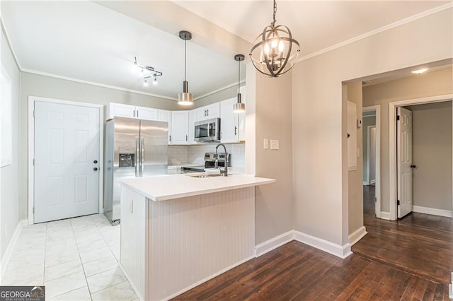 kitchen with kitchen peninsula, pendant lighting, stainless steel appliances, decorative backsplash, and white cabinets