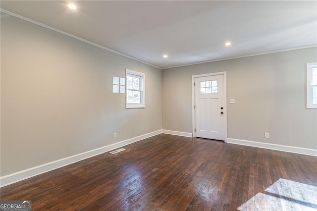 entrance foyer featuring dark hardwood / wood-style flooring, crown molding, and plenty of natural light