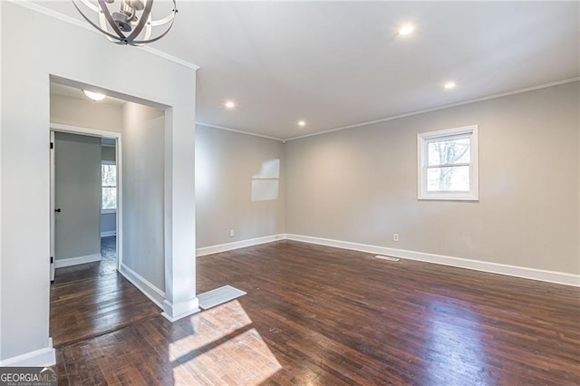 unfurnished room featuring crown molding, dark hardwood / wood-style flooring, and a chandelier