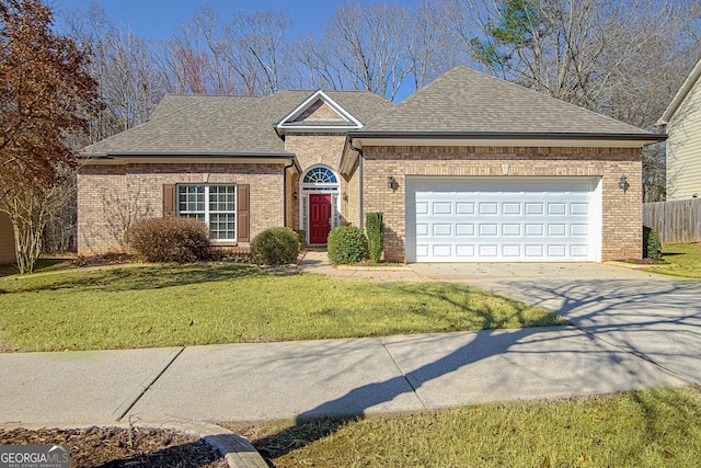 view of front of home with an attached garage, a shingled roof, brick siding, concrete driveway, and a front yard