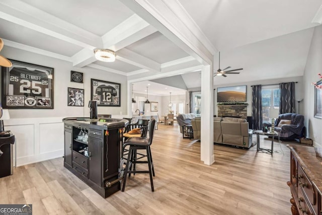 dining room with ceiling fan, ornamental molding, and light wood-type flooring