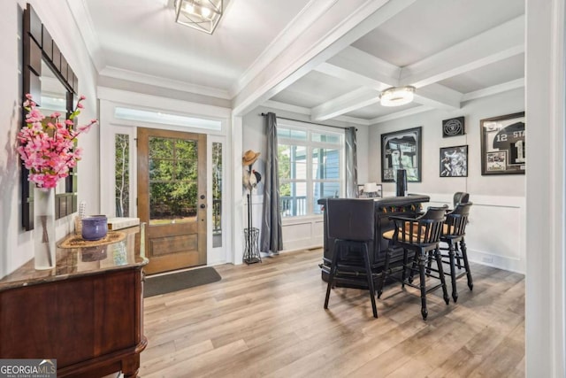 dining area with light hardwood / wood-style floors, crown molding, beamed ceiling, and coffered ceiling