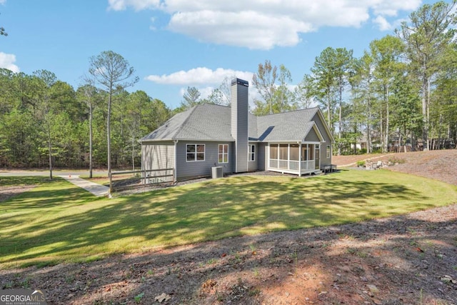 rear view of property featuring a sunroom, a yard, and central air condition unit