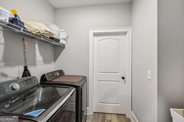 clothes washing area featuring light hardwood / wood-style floors and independent washer and dryer