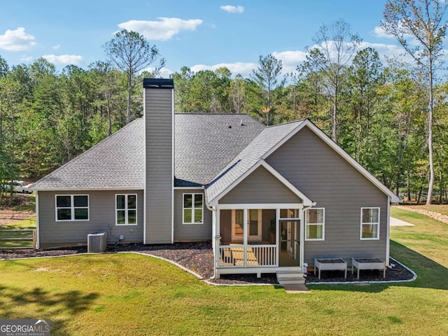 back of house with central AC unit, a yard, and a sunroom