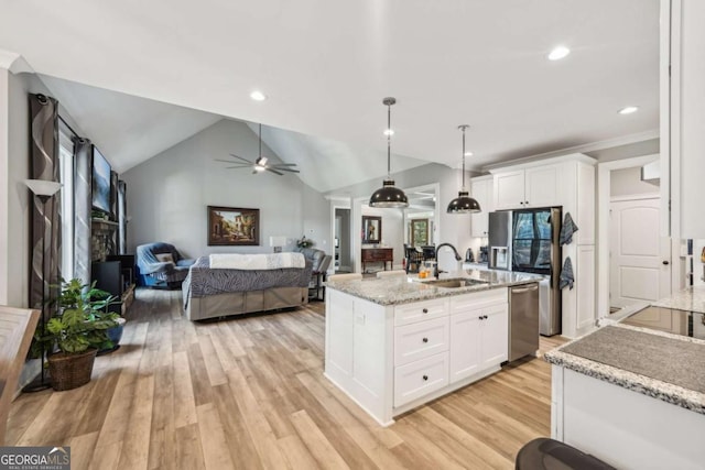 kitchen with white cabinets, appliances with stainless steel finishes, lofted ceiling, decorative light fixtures, and sink