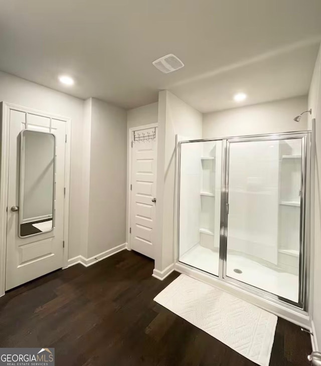 bathroom featuring a shower with shower door and hardwood / wood-style floors