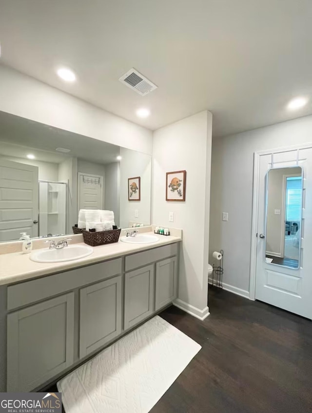 bathroom with walk in shower, vanity, and hardwood / wood-style floors