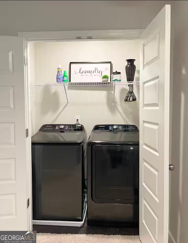 clothes washing area with carpet and washer and clothes dryer