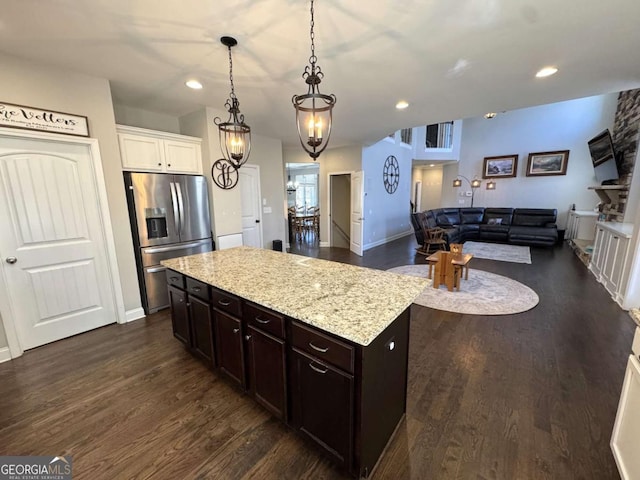 kitchen with pendant lighting, dark brown cabinets, white cabinetry, dark wood-type flooring, and stainless steel fridge