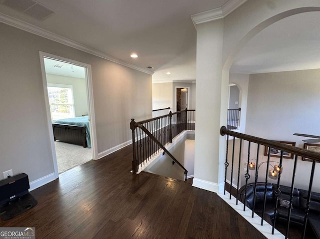 hallway with dark hardwood / wood-style floors and crown molding