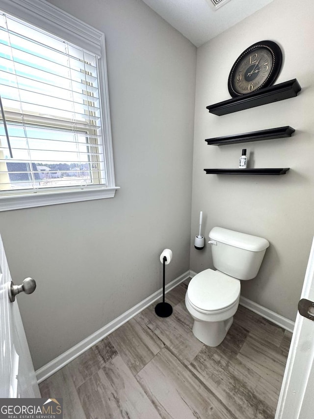 bathroom with toilet and hardwood / wood-style floors