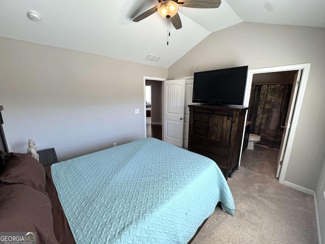 bedroom featuring ceiling fan, ensuite bath, vaulted ceiling, and light colored carpet