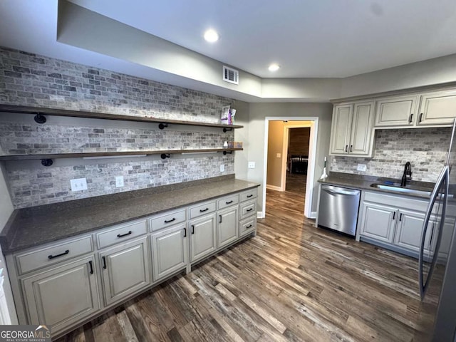 kitchen featuring gray cabinets, decorative backsplash, dark wood-type flooring, dishwasher, and sink