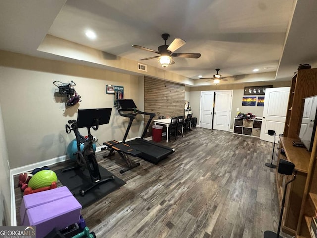 exercise area with hardwood / wood-style floors and a tray ceiling