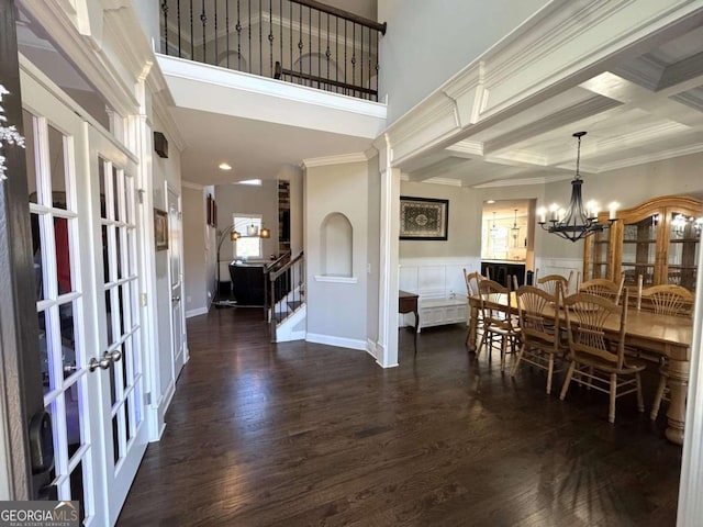 dining area with beam ceiling, dark hardwood / wood-style flooring, crown molding, and coffered ceiling