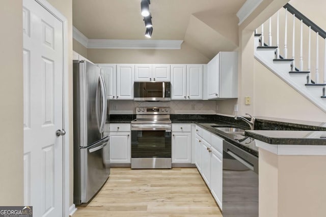 kitchen featuring decorative backsplash, sink, white cabinets, and stainless steel appliances