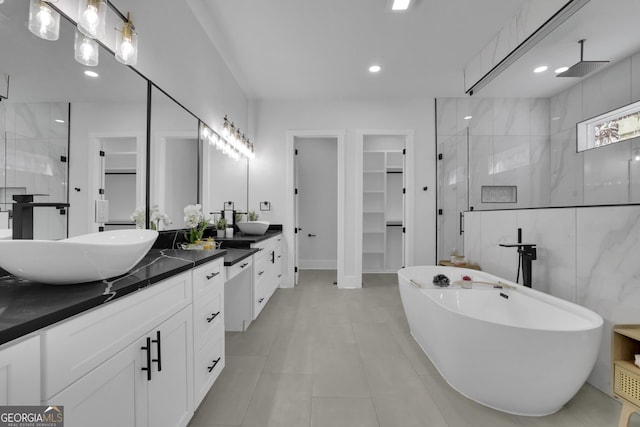 bathroom with tile patterned flooring, vanity, and plus walk in shower