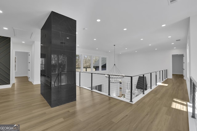 hallway featuring light hardwood / wood-style flooring and a notable chandelier