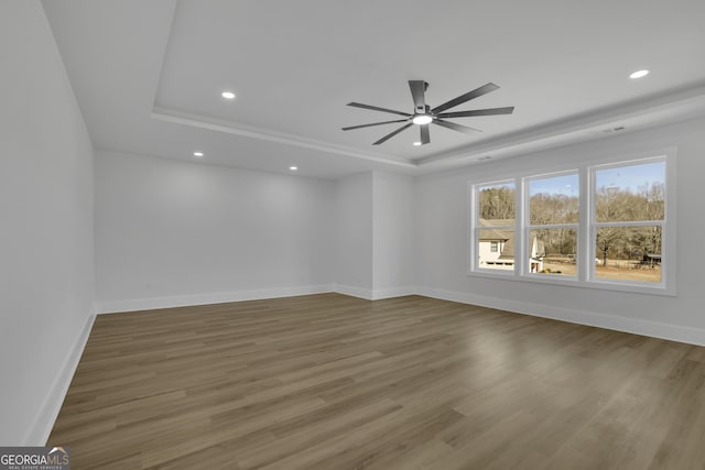 spare room featuring ceiling fan, a tray ceiling, and hardwood / wood-style flooring