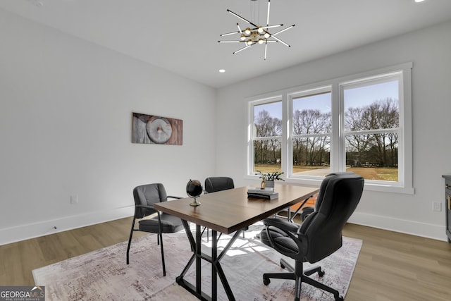 office area with wood-type flooring and an inviting chandelier