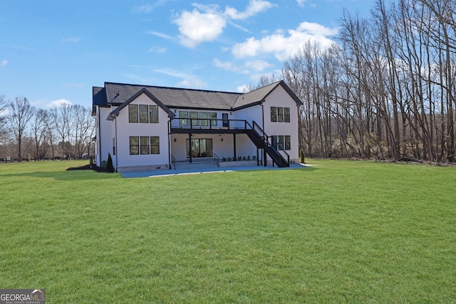 back of property with a deck, a patio area, and a yard