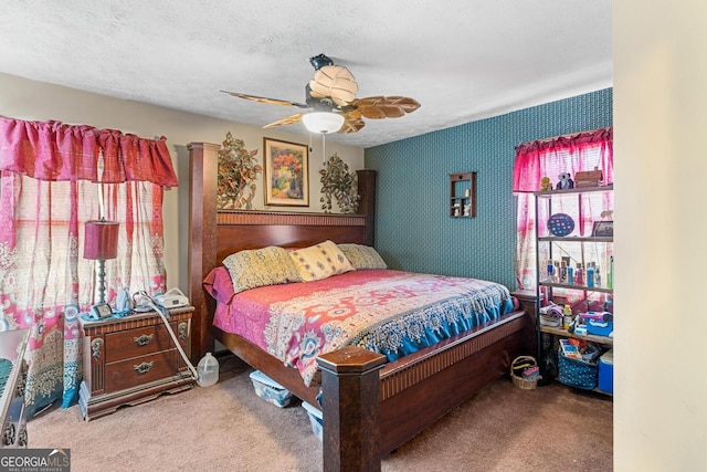 bedroom featuring a textured ceiling, ceiling fan, and carpet floors