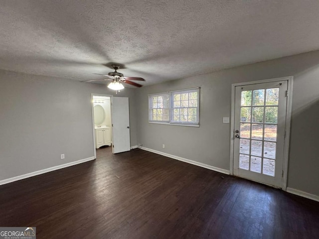 spare room featuring a textured ceiling, dark wood-type flooring, and ceiling fan