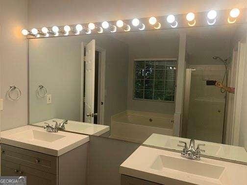 bathroom featuring vanity and separate shower and tub