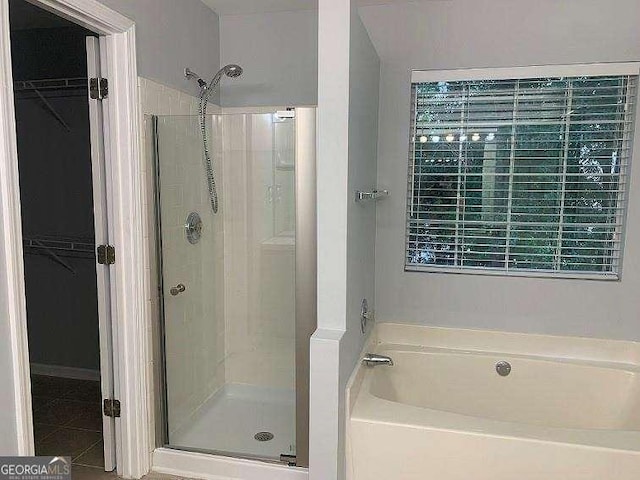 bathroom with tile patterned floors and shower with separate bathtub