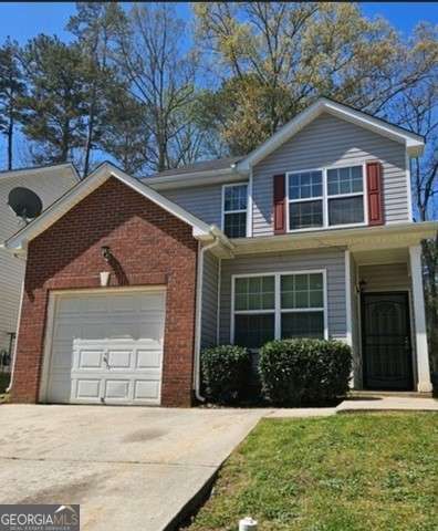 view of property featuring a front yard and a garage