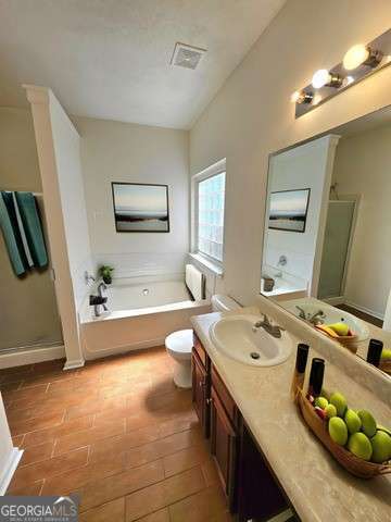 full bathroom with shower with separate bathtub, toilet, vanity, and tile patterned flooring