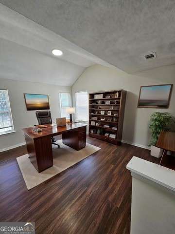 office area featuring vaulted ceiling and dark wood-type flooring