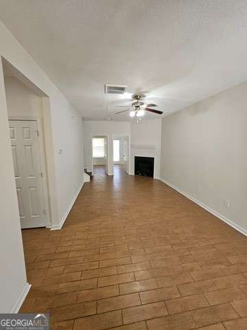 unfurnished living room featuring ceiling fan and light wood-type flooring