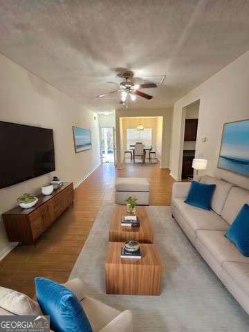 living room featuring ceiling fan and hardwood / wood-style floors