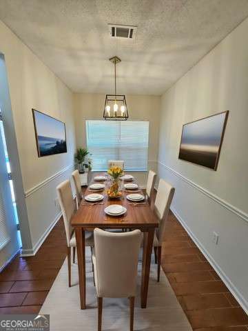 dining space with dark hardwood / wood-style flooring and a chandelier