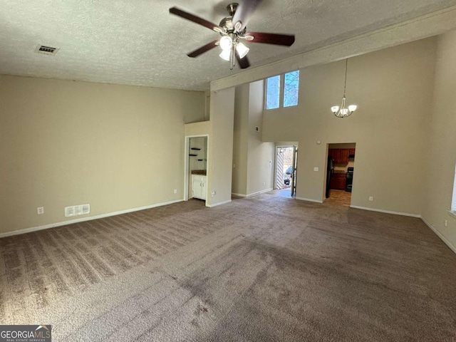 unfurnished living room featuring carpet floors, a high ceiling, a textured ceiling, and ceiling fan with notable chandelier