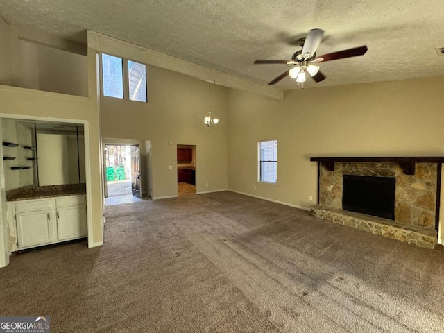 unfurnished living room featuring a towering ceiling, a textured ceiling, and carpet flooring