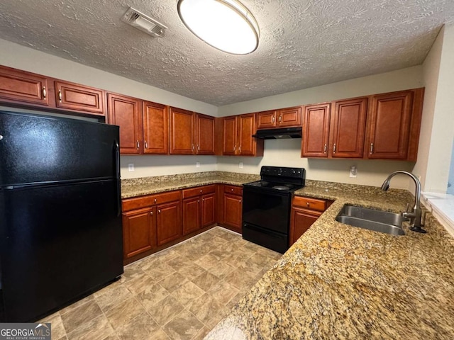 kitchen featuring light stone counters, sink, a textured ceiling, and black appliances