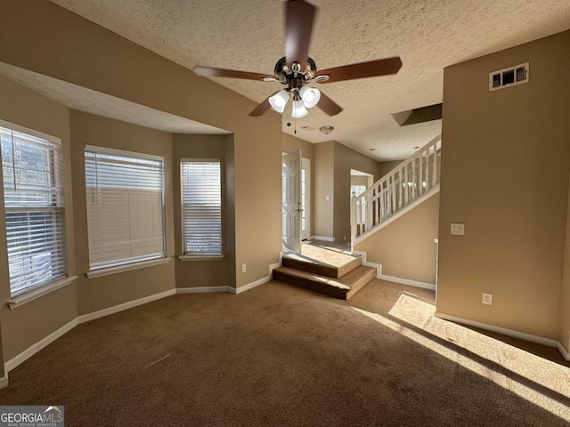 unfurnished living room with a textured ceiling, ceiling fan, and carpet floors